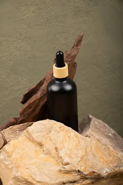 Kayanın üzerinde kahverengi etiketli doğal yağ şişesi.