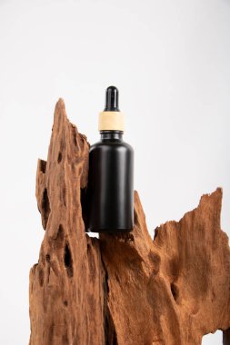 Beyaz arka planda siyah reçineli bir şişe parfüm.