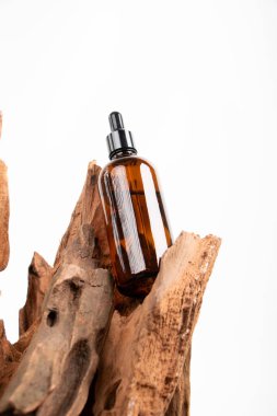 Beyaz arka planda kahverengi pipetli doğal kozmetik yağı şişesi..