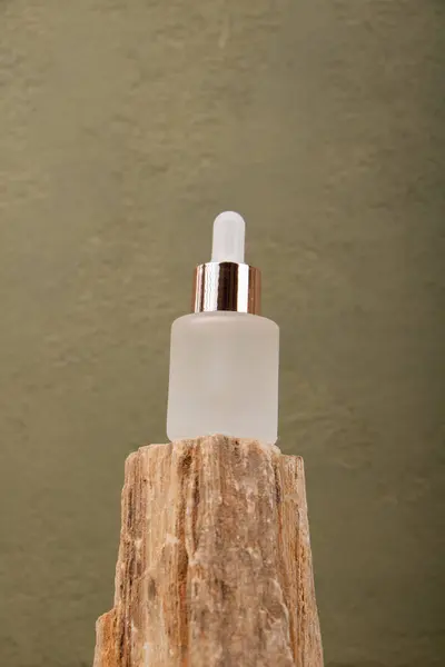 Kahverengi ahşap arka planda doğal serumu olan kozmetik şişesi.