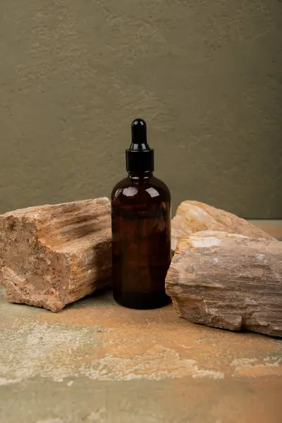 Kahverengi arka planda bir şişe doğal yağ.
