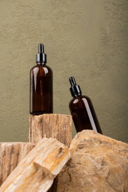 Doğal kozmetik ürünleri. Kahverengi arka planda gerekli yağ şişeleri. Spa ve güzellik konsepti. Boşluğu kopyala