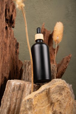 Ahşap arka planda siyah bir parfüm şişesi