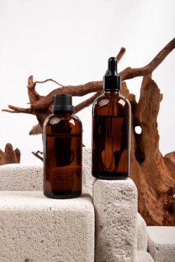 Kozmetik kremalı şişeler ve masada kuru dallar.