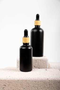 Beyaz arka planda doğal kozmetik ürünleri olan iki şişe.