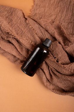kahverengi yağ şişesi ve kahverengi havlu. siyah şişe.