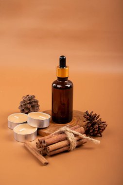 Temel gereksinim şişesi, tarçın çubukları ve kahverengi arka planda anason yıldızları. Doğal kozmetik. Kopyalama alanı olan düz.