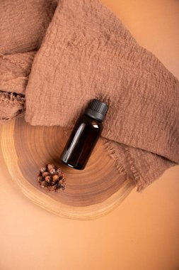 Kahverengi arka planda kahverengi tarçınlı cam yağ şişesi. Doğal yağ, doğal yağ, organik doğal ürün, spa, sağlık.