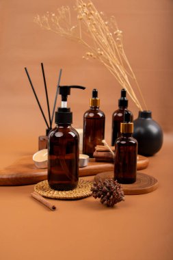 Bej arka planda gerekli yağ şişeleri ve çiçekler