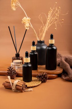 Masada yağlı şişeler ve kuru çiçekler var.