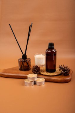 Bir şişe gerekli yağ, cam bir şişe, cam bir kavanoz ve bir çam ağacının arka planında bir mum. Doğal