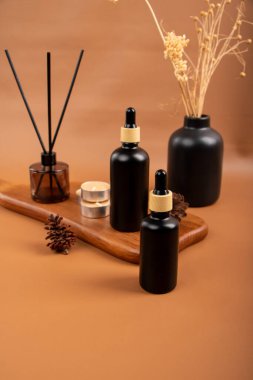 Doğal yağlı bir şişe ve ahşap zemin üzerinde tarçın çubukları.