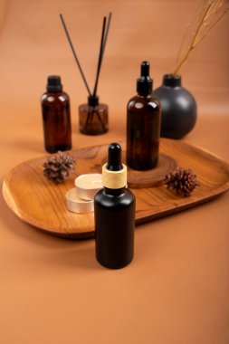 Esaslı yağ şişeleri ve kahverengi spa taşları kahverengi bir masada, yakın çekim.