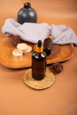 Kahverengi arka planda spa kompozisyonu. Şişesi ve gerekli yağı var. Masaj fırçası..