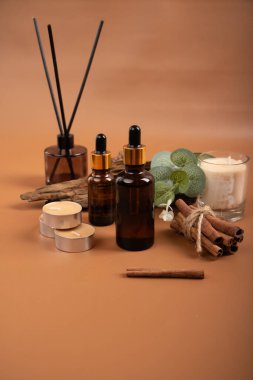 Doğal kozmetik şişeleri ve bej masa üzerinde gerekli yağ