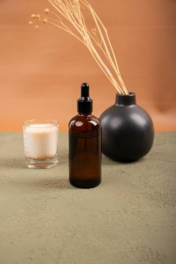 Cam şişe ve kozmetik şişe kahverengi sıvı ile bej arka planda fotokopi alanı ile