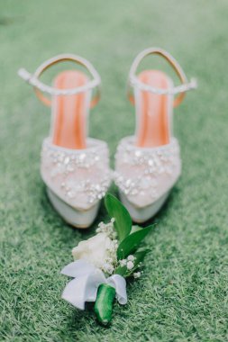 Gelinin göğüs zırhlı ayakkabıları yeşil çimlerin üzerine konur.