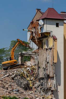 Uzhhorod, Ukrayna - 23 Mayıs 2023: Şehir bölgelerinden birinde eski bir binanın yıkılması üzerinde çalışan kazıcı.