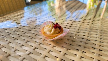 Yazın terasta beyaz bir masada meyveli lezzetli bir tatlı.