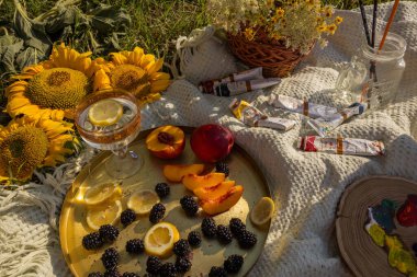 Birkaç meyve ve tabakta limon, kır çiçekleri, boya ve fırça renginden oluşan güzel bir kompozisyon..