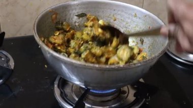 Gaz sobasıyla çelik kaplarda acı kabak pişiriyorlar.