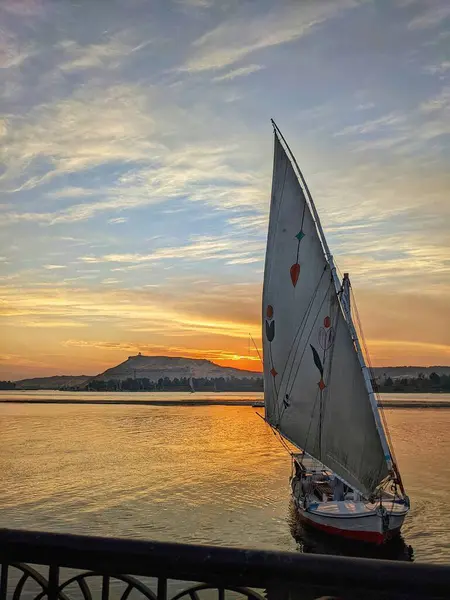 Geleneksel bir Felucca, güzel bir gündoğumunda Aswan yakınlarındaki Nil Nehri 'nde huzur içinde sürükleniyor..