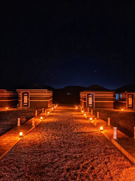 Wadi Rum, Ürdün 'de gece rahat kulübelere giden mum ışığında bir patika..