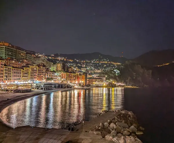 İtalya, Camogli 'nin güzel bir gece çekimi, sakin Akdeniz kıyı şeridi boyunca aydınlatılmış sahil kasabasını gösteriyor..