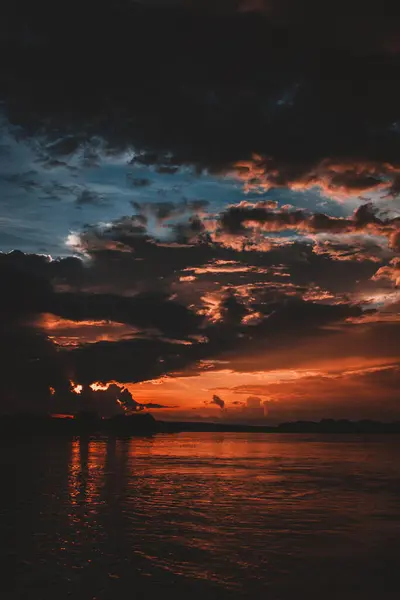 stock image An enchanting image capturing the vivid colors of a sunset over the Zambezi River with dramatic clouds and vibrant reflections on the water creating a mesmerizing and captivating scene perfect for visual projects.