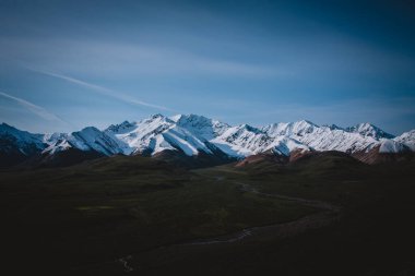 Alaska dağlarının nefes kesici güzelliğine ve yazın dolambaçlı bir nehir vadisine tanık olun. Doğa, macera ve sükunet temaları için mükemmel. Alaska 'nın el değmemiş vahşi doğasını gözler önüne seriyor..