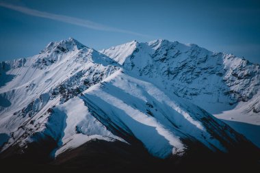 Karla kaplı Alaska dağlarının heybetli güzelliğini canlı, berrak gökyüzüyle yakala. Vahşi doğa, macera ve doğal güzellik temaları için mükemmel. Alaska 'nın engebeli manzarasının dingin ihtişamını gözler önüne seriyor..