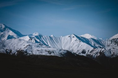 Alaska 'nın görkemli karla kaplı dağlarının berrak mavi gökyüzünün altında huzur veren güzelliğini hissedin. Doğa, macera ve seyahat teması için mükemmel. Dokunulmamış vahşi doğanın özünü yakalamak için..