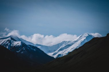 Alaska 'nın karlı dağlarının nefes kesici güzelliğini yakalayın. Bu çarpıcı manzara, temiz gökyüzüne karşı el değmemiş zirveleri sergiliyor. Seyahat, doğa ve macera projeleri için ideal..