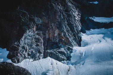 Bu çarpıcı hava görüntüsü Alaska 'daki bir buzul uçurumunun engebeli güzelliğini yansıtıyor. Koyu kayayla el değmemiş buz arasındaki dramatik zıtlığı vurguluyor. Doğa ve macera temaları için mükemmel.