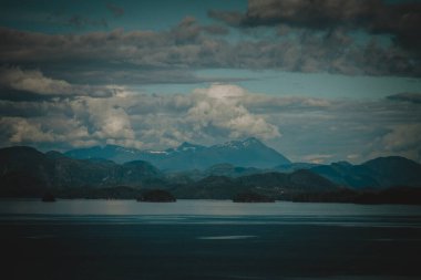 Kara, düşünceli bulutlar engebeli bir Alaska sıradağının üzerinde süzülüyor, güçlü ve karamsar bir manzara yaratıyor, dramatik, huşu uyandıran doğal manzaraya ihtiyaç duyan projeler için mükemmel..