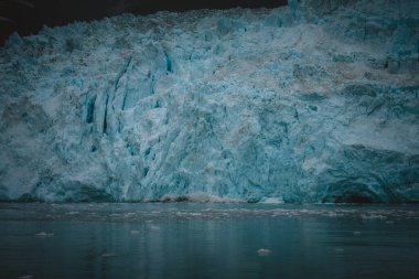 Kendini bir Alaska buzulunun nefes kesici güzelliğine daldır. Bu yüksek çözünürlüklü görüntü, dingin ihtişamı ve karmaşık buz oluşumlarını yakalar, doğa ve seyahat meraklıları için mükemmeldir..