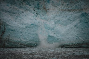Doğanın ham gücüne tanık olun. Alaska 'da bir buzul buzağısı gelişiyor. İklim değişikliği, doğal afetler ve kutup bölgelerinin güzelliği üzerine eğitim içeriği için mükemmel..