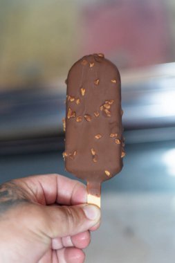Elindeki çubukta çikolatalı dondurma
