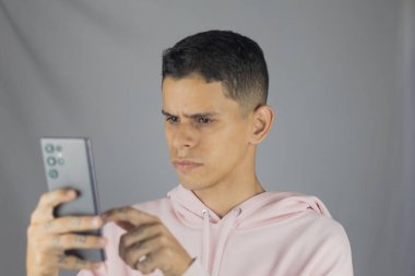 Genç adam akıllı telefonu elinde tutuyor ve video görüşmesi yapıyor. yüksek kaliteli fotoğraf