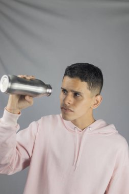 Gri arka planda feneri olan genç bir adam..