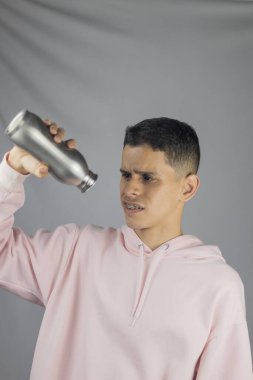 Elinde bir teneke su tutan genç adam.