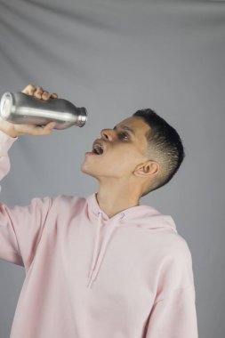 Bira şişesi ve bardak taşıyan genç bir adam portresi.