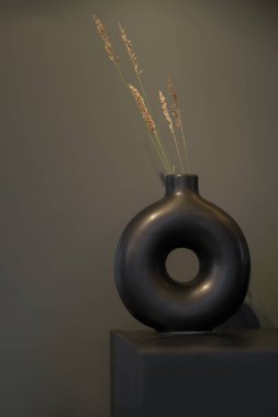 Yuvarlak Modern siyah vazo. Siyah masa üzerinde bir delik ve kopya alanı var.