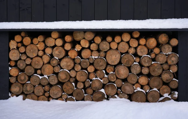 Brennholz Bei Schneefall Unter Haus Gestapelt — Stockfoto