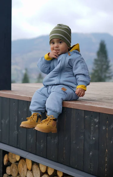 Porträt Eines Entzückenden Babys Das Auf Der Terrasse Sitzt Und lizenzfreie Stockfotos
