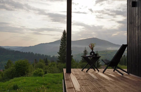 wooden outdoor furniture on terrace with mountain view in Ukraine