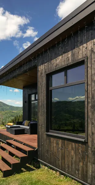Dağ manzaralı büyük siyah ahşap kulübe penceresi