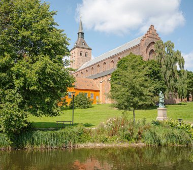 St. Canute Kilisesi ve Odense 'deki bahçesi 3 Ağustos 2024' te Danimarka 'nın nehir kıyısından görüldü.