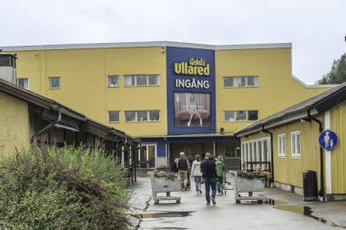 People with shopping carts walking to the entrance of GeKas Ullared, Sweden, August 16, 2024 clipart