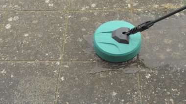 yüksek basınçlı çamaşır makinesi çimento karolarına köpüklü su püskürtüyor çimento ve toprakla kaplanmış.